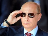 AFP/Scanpix nuotr./Vladimiras Putinas taisosi akinius nuo saulės žiūrėdamas lakūnų pasirodymą