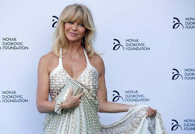 Scanpix nuotr. / Goldie Hawn pozuoja fotografams Novak Djokovic labdaros fondo vakarienėje Londone. 