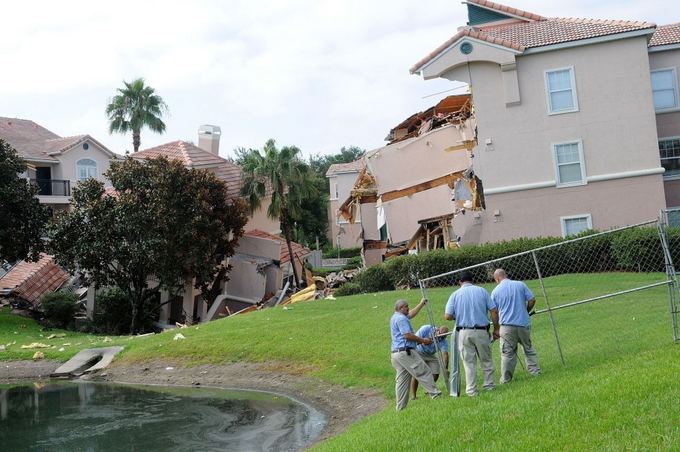 AFP/Scanpix nuotr./Floridoje atsivėrusi smegduobė prarijo dalį namo.