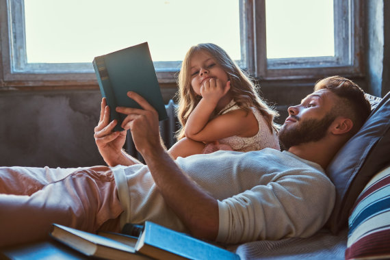 Photo from 123RF.com/Dad reads a book to his daughter